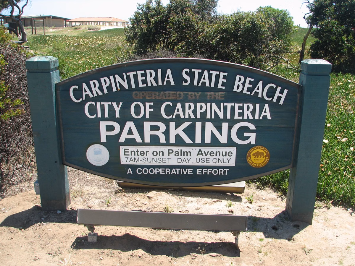 Carpinteria State Beach and City of Carpinteria parking sign directing visitors to enter on Palm Avenue