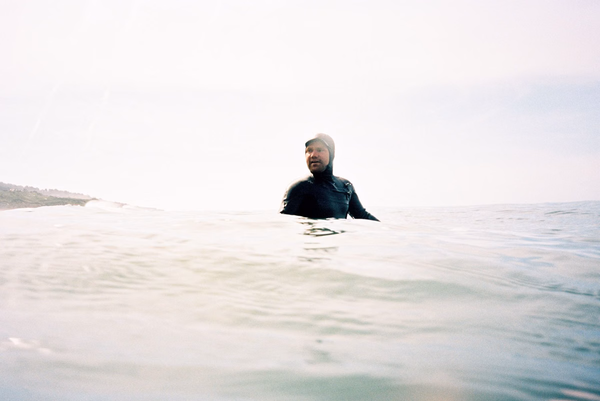 Surfer waiting in glassy water on a calm morning